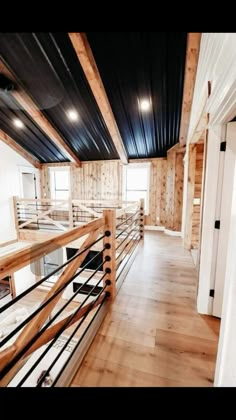 an empty room with wood floors and metal railings