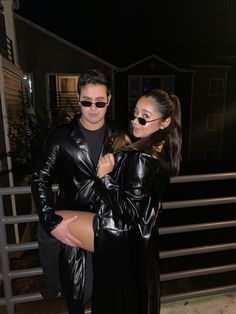 a man and woman dressed in black posing for the camera