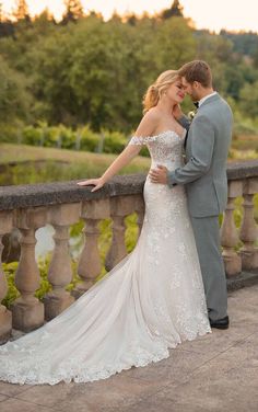 a bride and groom standing on a bridge