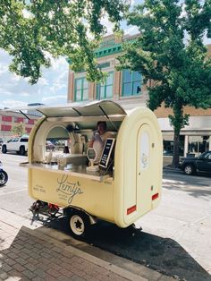 a food cart is parked on the side of the road with a man behind it