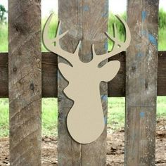 a deer head mounted to the side of a wooden fence