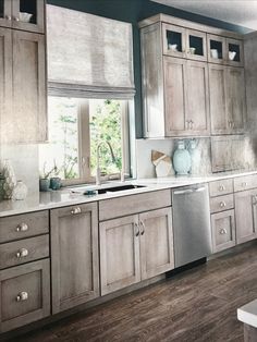 a kitchen with wood floors and cabinets in the middle of it, including a dishwasher