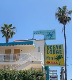 an ocean lodge hotel sign and palm trees