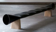 a wooden bench with black leather seats on it's legs and one section is bent to the side