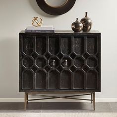 a black cabinet sitting next to a clock on top of a wall