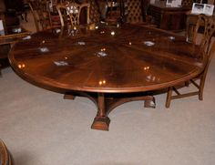 a large wooden table surrounded by chairs in a room with carpeted floor and walls