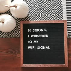 a sign that says be strong, i whispered to my wifi signal next to some pumpkins