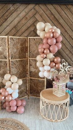 some balloons are hanging from the ceiling in front of a chair and table with other decorations