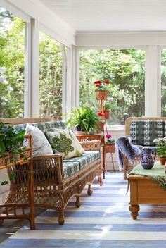 a sun room with wicker furniture and potted plants