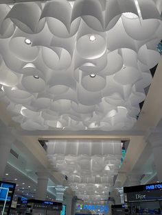 the ceiling is decorated with white paper circles and lights that are suspended from the ceiling