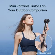 a woman is holding an umbrella in front of the ocean with text that reads, mini portable turbo fan your outdoor companion