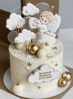 a white cake with gold decorations and an angel on top