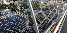 a close up of a fence with water in the background