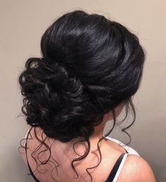 the back of a woman's head with black hair in a low updo