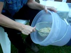 a person holding a plastic container with food in it while sitting on a lawn chair