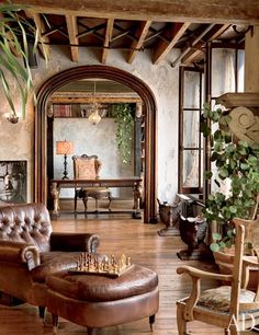 a living room filled with furniture and a large mirror on the wall above it's doorway