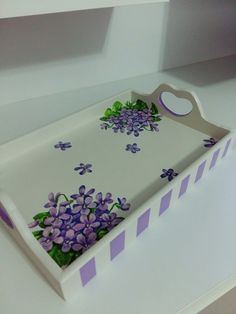 a white tray with purple flowers painted on it