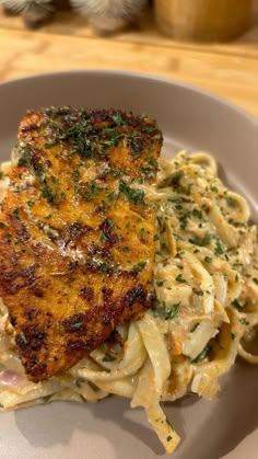 a white plate topped with pasta and meat