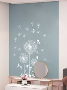 a room with a mirror and a dandelion wall decal on the wall