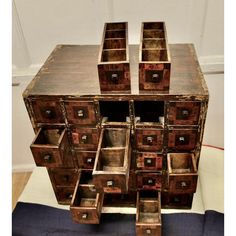 an old wooden chest with many drawers on it's sides and one drawer open