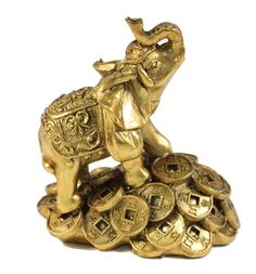 an elephant figurine is sitting on top of some gold coin stacks and it looks like he's going to jump