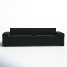 a black couch sitting on top of a white floor