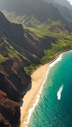 an aerial view of the ocean and mountains with a boat in the water near by