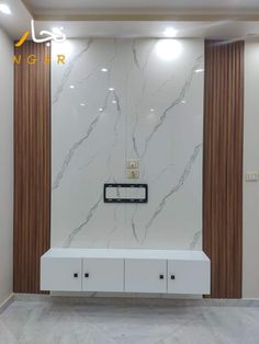 an empty room with marble walls and white cabinets