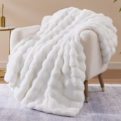 a large white blanket sitting on top of a chair