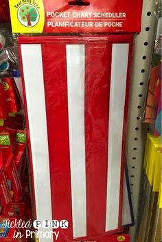 a large red and white striped box for sale in a store with other items on the shelves