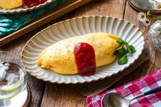 an omelet on a paper plate with raspberry sauce