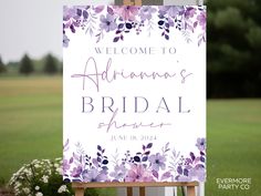 a welcome sign for the bride and groom in front of a grassy field with flowers