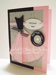 a handmade card with a pink dress and black cat on it's back