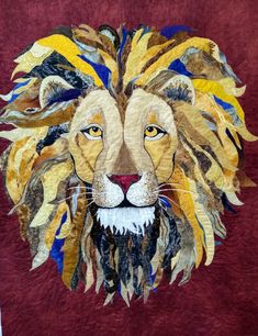 a close up of a quilt with a lion's face on it