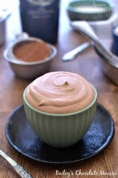 there is a bowl with some kind of chocolate frosting in it on the plate