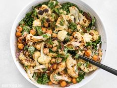 a white bowl filled with cauliflower, chickpeas and lettuce