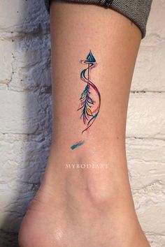 a woman's foot with an arrow tattoo on it