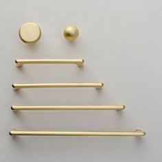 a set of four brass handles and knobs on a white wall with a round button