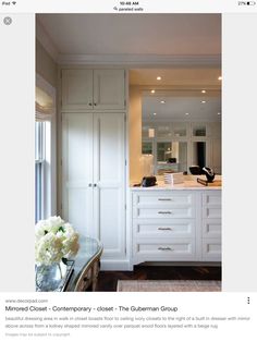 an image of a kitchen with white cabinets and flowers on the counter top in front of it