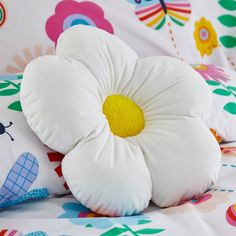 two pillows with flowers on them sitting on a bed