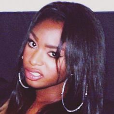 a close up of a person with large hoop earrings on her head and long hair