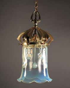 a glass light fixture hanging from a ceiling