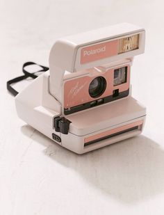 an old polaroid camera sitting on top of a white table