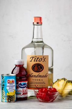 ingredients to make an alcoholic cocktail including pineapples, cherries and rum