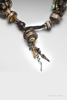 a necklace with some charms attached to it's sides and an arrow in the middle