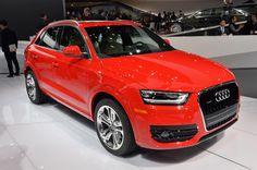 a red car is on display at an auto show