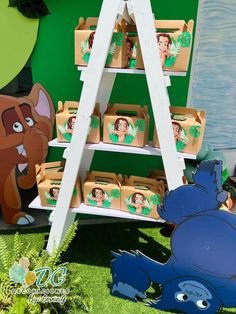 an animal themed birthday party is set up in front of a wall with cartoon characters on it