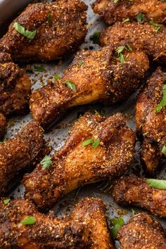 chicken wings with parsley on top in a pan