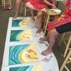 three people sitting on chairs in front of paintings