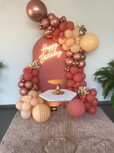 balloon arch with happy birthday sign and balloons on the wall in front of an entrance